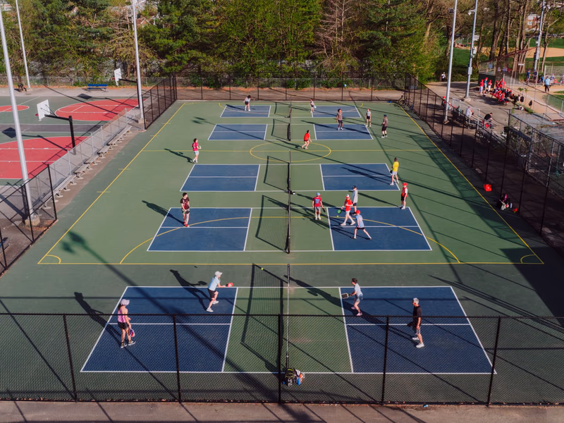 Outdoor pickleball courts with players in an active community