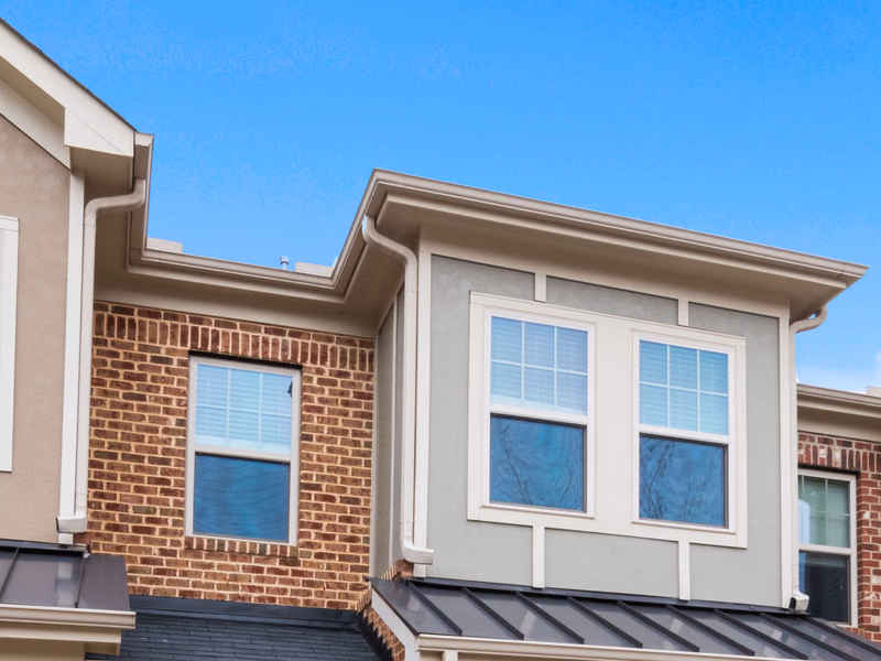 Neutral attached townhomes with beige, ivory, light gray, and brick exterior finishes